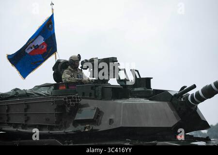 U.S. Army Lt. Col. William Branch, groupement tactique multinational de l'OTAN Pologne commandant de la 1re division blindée, 3e division d'infanterie, soutenant la Task Force Iron, exploite un char de combat principal M1A2 System Enhanced Package V3 Abrams lors d'un exercice conjoint de tir réel à Bemowo Piskie Training Area, Pologne, le 17 juillet 2025. Les soldats américains ont Uni leurs forces aux troupes roumaines et britanniques pendant le CALFEX, pour démontrer leur capacité à se déployer rapidement, à engager et à manœuvrer contre les forces ennemies dans des conditions de jour et de nuit. La mission de Task Force Iron est de s’engager dans la formation multinationale et Banque D'Images