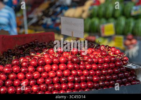 Cerises fraîches. Cerises soigneusement disposées sur un comptoir dans un marché local. Saison des baies d'été et des fruits, marché fermier Banque D'Images