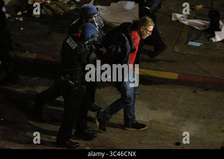 8 juin 2020, Seattle, Washington, États-Unis : des policiers arrêtent une personne lors d'affrontements entre manifestants et policiers lors d'affrontements entre policiers et manifestants près du quartier est du Departmentâ police de Seattle peu après minuit à Seattle, Washington, le 8 juin 2020. Plus tôt dans la soirée, un suspect est entré dans la foule de manifestants et a tiré sur une personne, ce qui s'est produit après une journée de manifestations pacifiques dans la ville. Plus tard, la police et les manifestants se sont affrontés violemment. (Crédit image : © David Ryder/ZUMA Wire) Banque D'Images