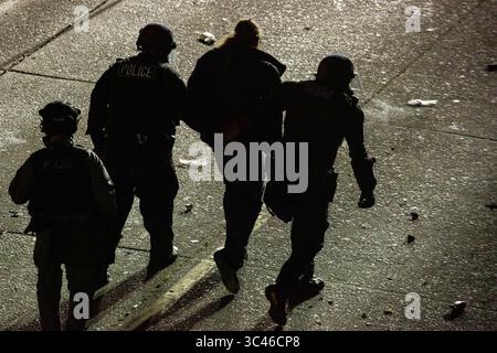 8 juin 2020, Seattle, Washington, États-Unis : des policiers arrêtent une personne lors d'affrontements entre manifestants et policiers lors d'affrontements entre policiers et manifestants près du quartier est du Departmentâ police de Seattle peu après minuit à Seattle, Washington, le 8 juin 2020. Plus tôt dans la soirée, un suspect est entré dans la foule de manifestants et a tiré sur une personne, ce qui s'est produit après une journée de manifestations pacifiques dans la ville. Plus tard, la police et les manifestants se sont affrontés violemment. (Crédit image : © David Ryder/ZUMA Wire) Banque D'Images