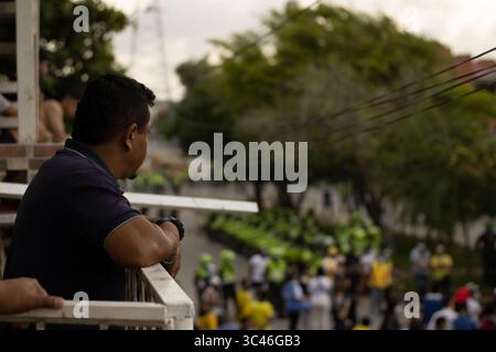 8 juin 2021, Barranquilla, Atlantico, Colombie : un homme regarde des manifestants protester alors que les équipes colombienne et Argentine disputaient un match de qualification pour la Coupe du monde FIFA Quatar 2022 au stade Metropolitano Roberto Melendez, les manifestations autour du stade ont dégénéré en affrontements avec la police anti-émeute colombienne contre les troubles et la brutalité policière, à Barranquilla, Colombie, le 8 juin 2021. (Crédit image : © Alex Ditta/LongVisual via ZUMA Wire) Banque D'Images