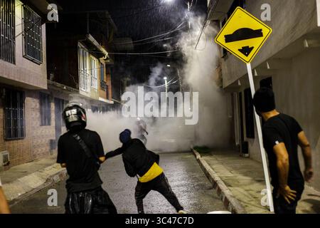 14 juin 2021, Yumbo, Valle del Cauca, Colombie : les manifestants jettent des pierres et débordent alors qu'un nuage de gaz lacrymogène remplit une rue alors que les manifestants et la police anti-émeute colombienne (ESMAD) s'affrontent dans la nuit du 14 juin 2021, à Yumbo - Cali, Valle del Cauca - Colombie alors que les manifestations antigouvernementales dévoilent dans leur 7ème semaine contre le gouvernement du président Ivan Duque, troubles et violence qui avaient causé au moins 70 morts. (Crédit image : © Muricio Romero/LongVisual via ZUMA Wire) Banque D'Images