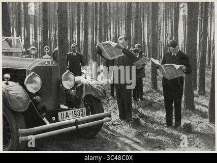9 mai 2018 - Allemagne - Adolf Hitler et entourage debout aux côtés de sa Mercedes pendant la lecture de journaux dans les bois, Allemagne, début des années 1930 (crédit image : © JT Vintage/Glasshouse via ZUMA Wire) Banque D'Images