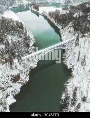 Vue aérienne du premier pont de la rivière Tadami traversant le paysage enneigé et les eaux sombres, Mishima, Fukushima, Japon. Banque D'Images