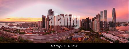 Vue aérienne de l'Opéra de Sydney et du Harbour Bridge, embrassés par les gratte-ciel de la ville sous un coucher de soleil vibrant, Sydney, Nouvelle-Galles du Sud, Australie. Banque D'Images