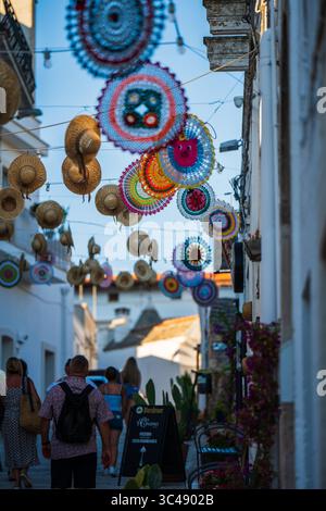 Rue décorée de chapeaux suspendus à Alberobello, Pouilles, Italie Banque D'Images