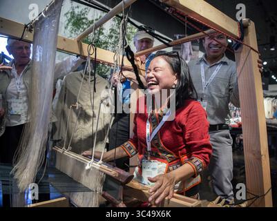 12 juillet 2018 - Etats-Unis - Khamchanh Khoutthao, du Laos, rit lors de l'effondrement imminent d'un métier à tisser qu'elle utilisait pour tisser une écharpe en soie chez Santa Fe Dry Goods à Santa Fe, jeudi 12 juillet 2018. Le métier à tisser était tenu à rassembler par des cordons élastiques et des bénévoles pendant les manifestations. Elle sera parmi les centaines d’artistes qui présenteront leur artisanat au marché international d’art folklorique de Santa Fe qui commence vendredi et se poursuit jusqu’au dimanche sur Museum Hill. Khoutthao était l'un des nombreux artistes qui démontraient leur artisanat jeudi dans des endroits autour de Santa Fe. (Crédit image : © Eddie Moore/Albuquerque Banque D'Images
