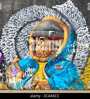 À Oaxaca, au Mexique, un squelette de bombe pulvérisable dans un sweat à capuche et un bonnet surgit du mur dans cette murale urbaine audacieuse réalisée par des graffitis locaux. Banque D'Images