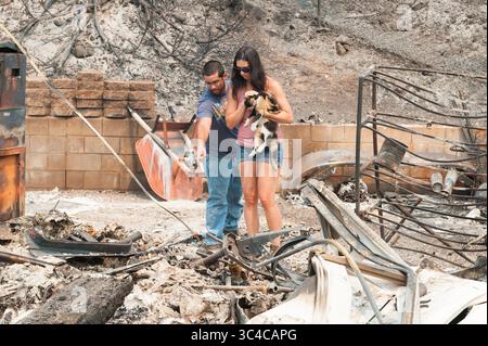 27 juillet 2018 - Redding, Californie, États-Unis - Chris et Celia Corona traversent les restes de la maison des parents de Chris dans le quartier de Lake Redding Estates à Redding, en Californie. Le couple est venu chercher ses parents chat Jynx, qui avait été trouvé dans un buisson près de la maison détruite. L'incendie de Carr a coûté la vie à deux personnes et est maintenant estimé à 44 450 acres et seulement 3% contenu. (Crédit image : © Mark McKenna via ZUMA Wire) Banque D'Images