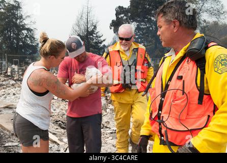 27 juillet 2018 - Redding, Californie, États-Unis - Ed Boontjer, à droite, avec le Shasta County Search and Rescue réunit Fluffy avec ses propriétaires, Keela et Wade Brilz dans le quartier de Lake Redding Estates à Redding, en Californie. Le couple a perdu sa maison dans l'incendie de Carr. Keela travaille avec Rick Bowser, deuxième à partir de la droite dans une firme d'ingénierie. L'incendie de Carr a coûté la vie à deux personnes et est maintenant estimé à 44 450 acres et seulement 3% contenu. (Crédit image : © Mark McKenna via ZUMA Wire) Banque D'Images