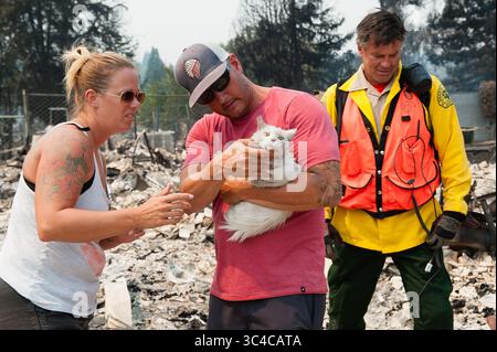 27 juillet 2018 - Redding, Californie, États-Unis - Ed Boontjer, avec le Shasta County Search and Rescue réunit Fluffy avec ses propriétaires, Keela et Wade Brilz dans le quartier de Lake Redding Estates à Redding, en Californie. Le couple a perdu sa maison dans l'incendie de Carr. L'incendie a coûté la vie à deux personnes et est maintenant estimé à 44 450 acres et seulement 3% contenu. (Crédit image : © Mark McKenna via ZUMA Wire) Banque D'Images