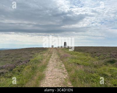 Deux grands cairns en pierre au sommet de la colline Twin Law, marquant des tombes légendaires, se dressant sur la lande de bruyères sous un ciel immense avec des vues panoramiques à travers les frontières Banque D'Images