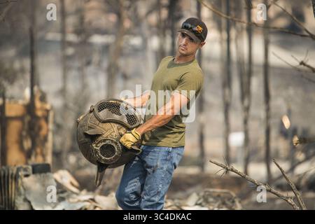 27 juillet 2018 - Californie, États-Unis - Austin Love, de Redding aide un ami à ramasser les morceaux de sa maison brûlée à Lake Redding Estates le vendredi 27 juillet 2018 après que le feu de Carr a traversé le quartier. (Crédit image : © Sacramento Bee via ZUMA Wire) Banque D'Images
