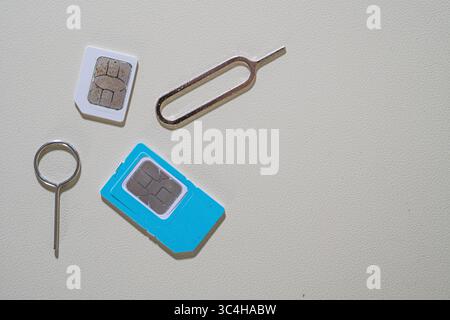 Macro gros plan de la carte SIM et de l'outil d'éjection du plateau SIM. Parfait pour les blogs techniques, les articles de réparation de smartphone, les tutoriels mobiles, ou les télécommunications-rela Banque D'Images
