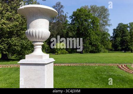 Vase en marbre pièce maîtresse dans un parc pittoresque, entouré d'herbe verte, d'arbres et d'une atmosphère calme. Améliorer la beauté tranquille de la nature avec son el Banque D'Images