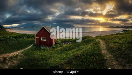 Cabine rouge sur Ramberg Beach au coucher du soleil, îles Lofoten, Norvège Banque D'Images