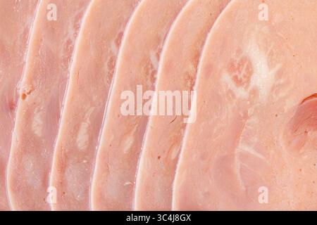 Tranches de jambon, saucisse finement tranchée. Fond de texture de jambon. Gros plan, vue de dessus. Photo de haute qualité Banque D'Images