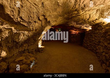 Intérieur d'une grotte volcanique formée par un ancien tube de lave avec des murs en pierre brute et un éclairage tamisé Banque D'Images
