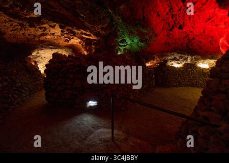 Intérieur d'une grotte volcanique formée par un ancien tube de lave avec des murs en pierre brute et un éclairage tamisé Banque D'Images
