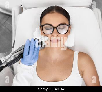 Belle femme ayant l'épilation au laser et l'épilation au laser de la zone des lèvres sur son visage au salon de cosmétologie Banque D'Images