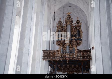 Gdansk, Pologne - 04-07-2025 - orgue antique majestueux décoré de bleu et d'or à l'intérieur d'une église catholique en pierre blanche Banque D'Images