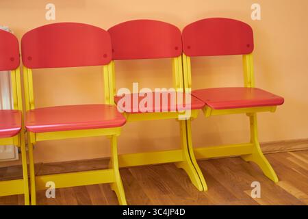 chaises d'enfants vides près du mur dans le jardin d'enfants Banque D'Images