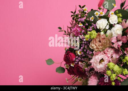 Un bouquet floral aux couleurs vives sur un fond rose. Roses, œillets, eustoma, alstromeria. Copyspace Banque D'Images