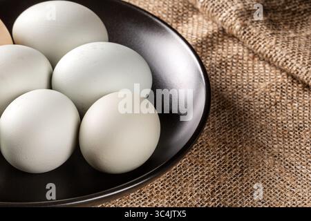 Explorez l'attrait visuel des œufs de poule respectueux de l'environnement disposés sur une belle table paysanne en bois vintage, représentant l'harmonie de F. Banque D'Images