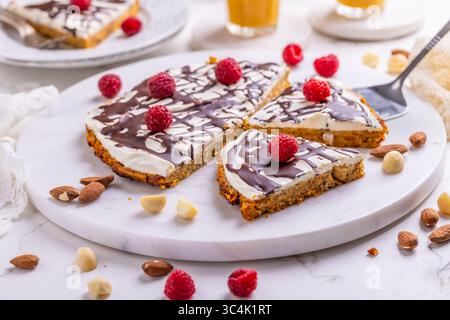 Gâteau plat aux carottes fait maison avec des noix, glacé avec du fromage à la crème et du jus de carotte Banque D'Images