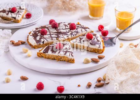 Gâteau plat aux carottes fait maison avec des noix, glacé avec du fromage à la crème et du jus de carotte Banque D'Images