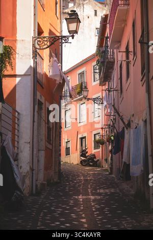 Lisbonne, Portugal - 15 mai 2025 : les pavés dans une ruelle étroite brillent au début de la lumière du soleil Banque D'Images