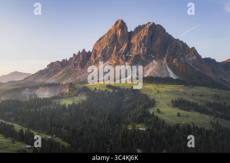 Vue aérienne de la majestueuse montagne Sass de Putia sous un ciel bleu, avec des prairies verdoyantes et des forêts denses en contrebas, Wurzjoch, Passo delle Erbe, Sout Banque D'Images