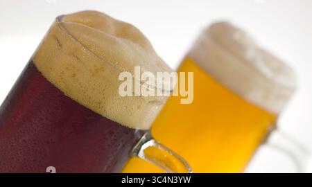 Deux tasses de bière foncée et légère avec mousse Banque D'Images