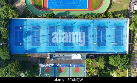 Vue aérienne des courts de tennis bleus avec joueurs et ombres Banque D'Images