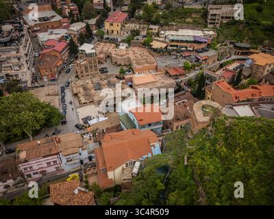 Vue aérienne des bains de soufre de la vieille ville contrastant avec la rivière Kura et les falaises verdoyantes, Tbilissi, Tbilissi, Géorgie. Banque D'Images