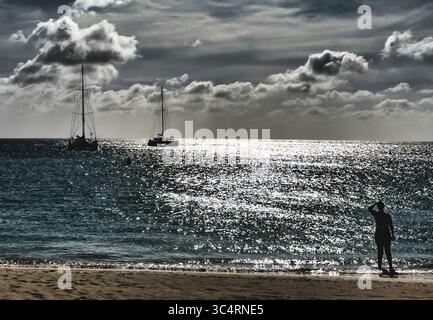 Coucher du soleil derrière les nuages sur une plage tropicale. Banque D'Images