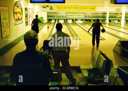 Bowling at Gay Games Hoofddorp, Hoofddorp, pays-Bas, 05-08-1998 Whizgle News, Dutch Desk, pays-Bas, 1950-2000 Un groupe de bowling se concentre sur leur jeu dans une piste de bowling animée, avec des décorations colorées et des enseignes en arrière-plan célébrant un événement. L'atmosphère évoque la compétition et la camaraderie alors que les joueurs se préparent à rouler leurs balles sur les voies polies. Banque D'Images