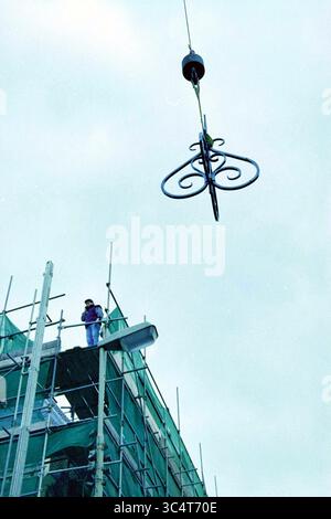 Lors de la restauration du Hoofdwacht, une girouette portant le logo de l’Association Haerlem sera placée sur une cheminée. La girouette a été faite par le forgeron ornemental AB Vermeulen. Grote Markt corner of Smedestraat, Haarlem., Haarlem, Smedestraat, pays-Bas, 02-11-1994 Whizgle News, Dutch Desk, pays-Bas, 1950-2000 Un ouvrier de la construction observe depuis un échafaudage une charpente métallique ornée est hissée vers le haut par une grue. Le ciel au-dessus de la tête est pâle, ajoutant une impression d'élévation à la scène. Banque D'Images