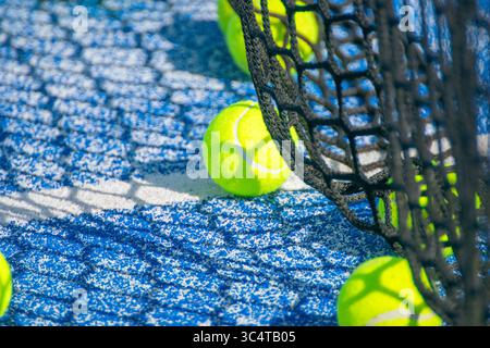 Balles de padel et une ombre nette sur un court bleu. Concept les motifs artistiques de la lumière dans le sport. Banque D'Images