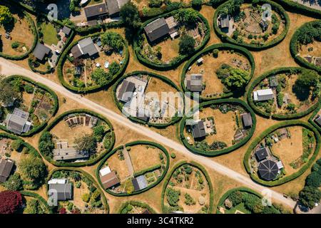 Vue aérienne des jardins ronds, un paysage fantaisiste de parcelles circulaires soigneusement entretenues, chacune un minuscule monde de haies verdoyantes et de maisons miniatures, Nærum, Danemark. Banque D'Images