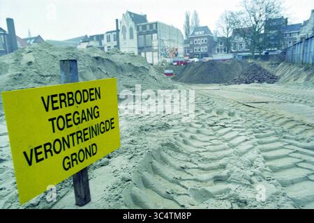 Site de Koningscarrée avec sol contaminé, Haarlem, Koningstraat, pays-Bas, 17-01-1996 Whizgle News, Dutch Desk, pays-Bas, 1950-2000 Un chantier de construction présente des tas de sable, de saleté et de grosses traces de pneus, avec un panneau jaune vif avertissant contre l'entrée en raison d'un sol contaminé. Les bâtiments voisins peuvent être vus en arrière-plan. Banque D'Images
