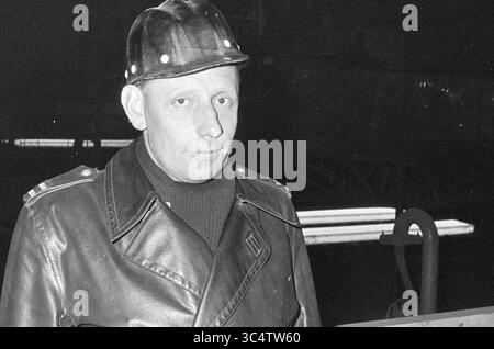 Service de sécurité sur les rondes de nuit, Hoogovens, 08-06-1961 Whizgle News, Dutch Desk, pays-Bas, 1950-2000 Un homme portant une casquette de pilote et une veste en cuir se tient confiant, dégageant un air d'autorité. L'arrière-plan fait allusion à un environnement industriel, probablement lié à l'ingénierie ou à la fabrication. Banque D'Images