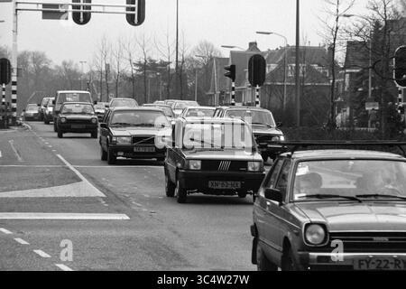 Trafic sur le Heemsteedse Dreef, Heemstede, Heemsteedse Dreef, pays-Bas, 23-01-1991 Whizgle News, Dutch Desk, pays-Bas, 1950-2000 Une scène de rue animée avec une file de voitures attendant à un feu de circulation, entourée de bâtiments résidentiels et de panneaux de signalisation. L'atmosphère suggère une journée typique de déplacements urbains. Banque D'Images