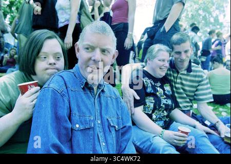 Poupée libération, Haarlem, public, Haarlem, pays-Bas, 04-05-2000 Whizgle News, Dutch Desk, pays-Bas, 1950-2000 Un groupe d'amis profitant d'un rassemblement décontracté, souriant et assis étroitement ensemble. Deux individus tiennent des tasses, tandis que l'atmosphère semble vive et joyeuse, avec d'autres se mêlant en arrière-plan. Banque D'Images