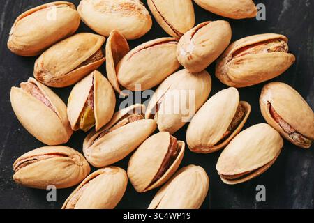 Pistaches en gros plan. Groupe de graines décortiquées naturelles. Collation biologique saine. Coquilles texturées marron. Ingrédient alimentaire savoureux. Pistaches grillées à sec. Banque D'Images