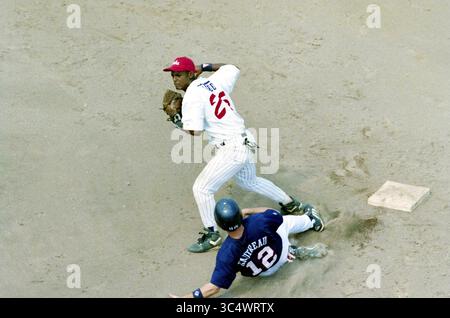 Final Cuba - USA, 12-08-2000 Whizgle News, Dutch Desk, pays-Bas, 1950-2000 Un joueur de baseball portant un maillot blanc avec des accents rouges se prépare à lancer la balle tandis qu'un autre joueur, glissant dans la base avec un maillot bleu, tente de le marquer. L'action capture l'intensité d'un jeu rapproché sur le diamant. Banque D'Images