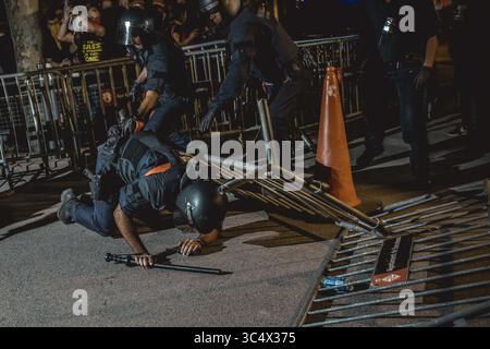 1 octobre 2018 - Barcelone, Catalogne, Espagne - des militants pro-indépendantistes catalans se rassemblent sur la place de Catalogne de Barcelone pour exiger la mise en œuvre du résultat du référendum sur la sécession à son anniversaire le 1er octobre. Un agent de la police anti-émeute catalane tombe au sol après que des militants pro-indépendantistes ont jeté une barrière pour briser le cordon policier devant le parlement catalan lors d'une manifestation pour la mise en œuvre du résultat du référendum sur la sécession à son anniversaire le 1er octobre. (Crédit image : © Matthias Oesterle/ZUMA Wire) Banque D'Images
