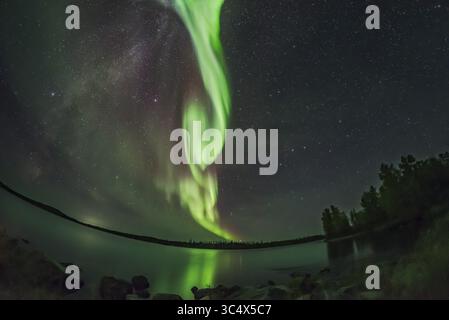 Le 9 septembre 2018 - Alberta, Canada - Un arc lumineux d'aurore au-dessus des eaux tranquilles du lac Tibbitt, à l'extrémité de la route Ingraham Trail, à l'est de Yellowknife, T.N.-O. C'était la nuit du 8 au 9 septembre 2018 lors d'une très belle exposition... Vega et Altaïr et la voie lactée sont à gauche. Big Dipper et Polaris sont à droite. ..ceci est une exposition unique pour le ciel, et un mélange moyen-empilé de 5 expositions pour le sol et l'eau pour lisser le bruit. Tous sont 6 secondes à f/2,8 avec l'objectif fish-eye plein format 12 mm Rokinon sur le Nikon D750 à 6400 ISO. (Crédit image : © Alan Dyer / Vwpics/V. Banque D'Images
