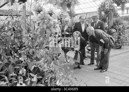 Ouverture Liliade, ouverture, ouvertures, mise en service, 10-05-1979 Whizgle News, Dutch Desk, pays-Bas, 1950-2000 Un groupe de personnes se réunit dans une serre, admirant un vif spectacle de fleurs. Un individu se penche vers le bas pour examiner les fleurs de près tandis que d'autres observent avec intérêt, montrant une appréciation partagée de la beauté de la nature. Banque D'Images