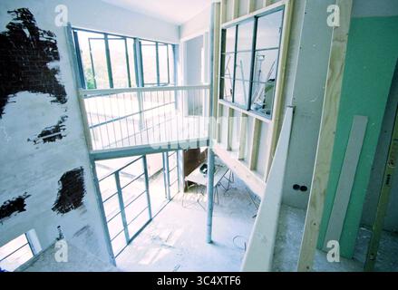 Intérieur de maisons et vieux hangar à ampoules, 08-06-2000 Whizgle News, Dutch Desk, pays-Bas, 1950-2000 un espace intérieur inachevé présente des murs et des cadres apparents, avec de grandes fenêtres permettant à la lumière naturelle de s'écouler. Un balcon donne sur la zone inférieure, où les outils et les matériaux sont dispersés, indiquant des travaux de construction en cours. Banque D'Images